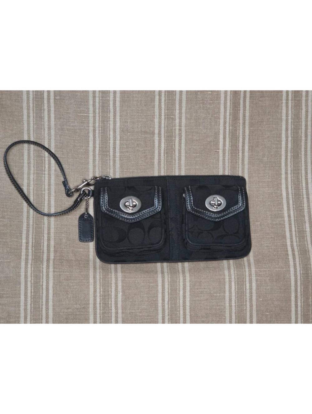 Coach black signature turnlock wristlet, dual front pockets, leather strap